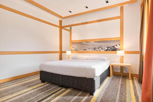 a hotel room with a bed and two lamps at Hotel Han Bjelašnica in Bjelašnica