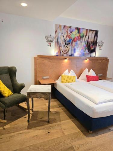 a hotel room with a bed and a chair at Boutique Hotel Goldenes Lamm Villach in Villach