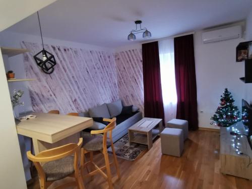 a living room with a table and a christmas tree at Apartman San in Vrnjačka Banja
