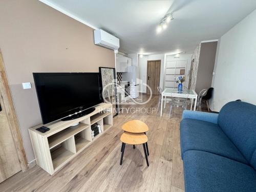 un salon avec un canapé bleu et une télévision dans l'établissement Appartement idéal famille - Centre-ville Juan-les-Pins, à Antibes