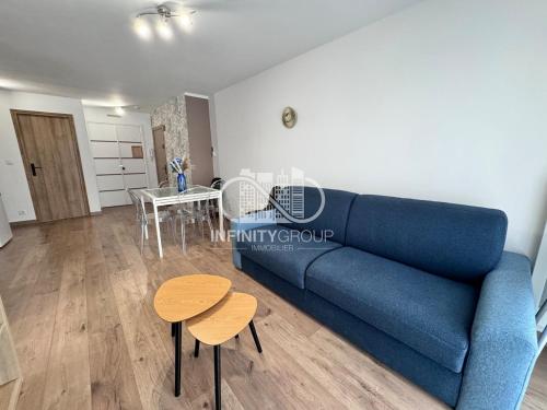 un salon avec un canapé bleu et une table dans l'établissement Appartement idéal famille - Centre-ville Juan-les-Pins, à Antibes