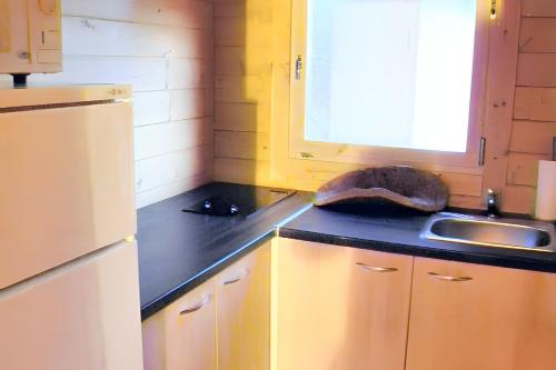 - une cuisine avec un plan de travail noir et un évier dans l'établissement Maison cosy Ajaccio avec jacuzzi, à Ajaccio