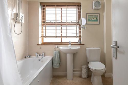 ein Badezimmer mit Badewanne, Waschbecken und Toilette in der Unterkunft The Boathouse for two, St Davids, Garage Parking in St. Davids