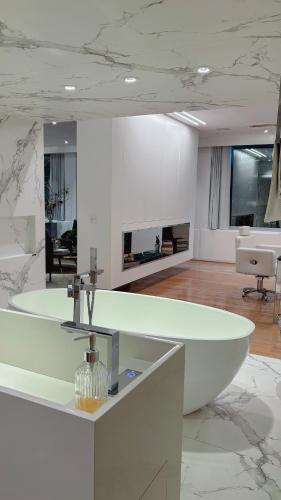 Habitación con baño con bañera blanca grande. en Refúgio da VILLA, en Gramado