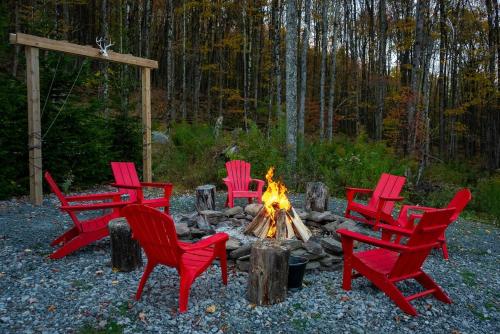 a group of red chairs around a fire pit at Belleayre Mountain House in Arkville