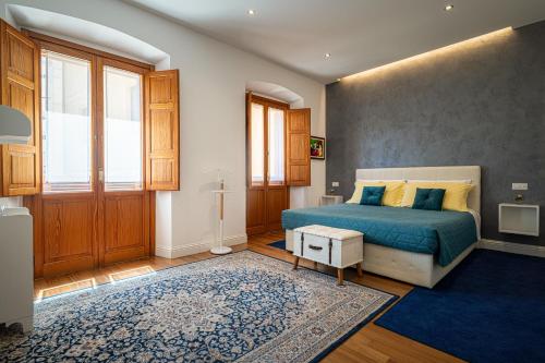 a bedroom with a bed and a blue rug at Marcus Suite in Cagliari