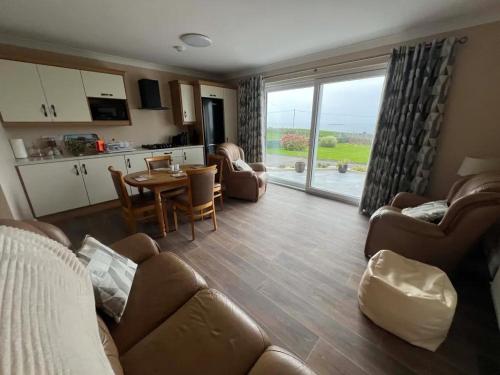 a living room with a couch and a table at Ocean Spray Self Catering apartment in Kilcar