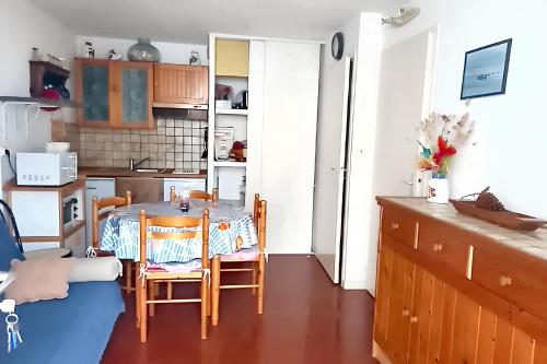 une cuisine avec une table et des chaises dans une pièce dans l'établissement Maison accueillante à Saint-Jean-de-Monts avec terrasse, à Saint-Jean-de-Monts