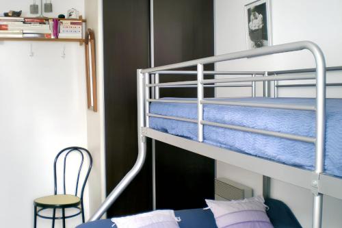 - une chambre avec 2 lits superposés et une chaise dans l'établissement Maison accueillante à Saint-Jean-de-Monts avec terrasse, à Saint-Jean-de-Monts