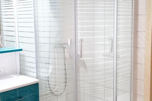 une douche avec une porte vitrée dans une salle de bain dans l'établissement Maison accueillante à Saint-Jean-de-Monts avec terrasse, à Saint-Jean-de-Monts