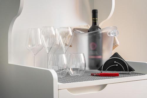 a shelf with glasses and a bottle of wine at Marcus Suite in Cagliari