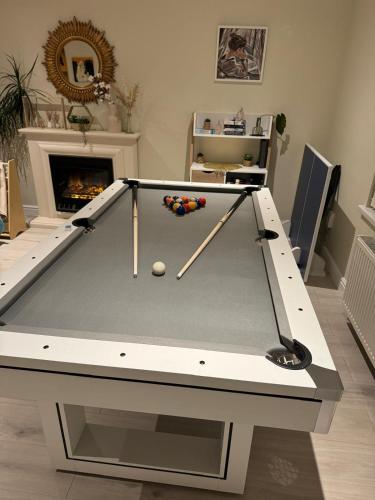 a snooker table in a living room with a fireplace at The Art Gallery Guest House - Newport Cozy 3-Bedroom Home in Newport