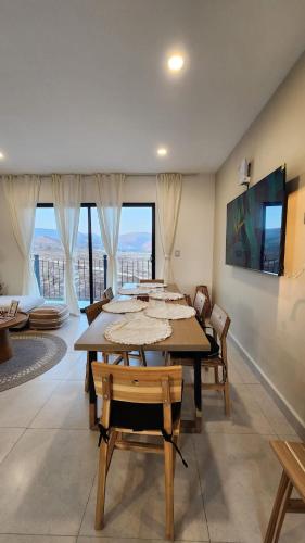 a dining room with tables and chairs and windows at Ensenada Valle PH in Ensenada