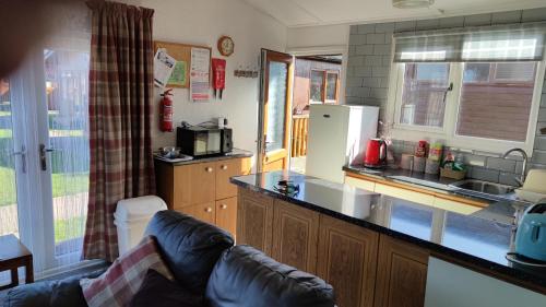 a kitchen with a refrigerator and a counter top at Quiet 6 berth pet friendly chalet near beach in Mablethorpe