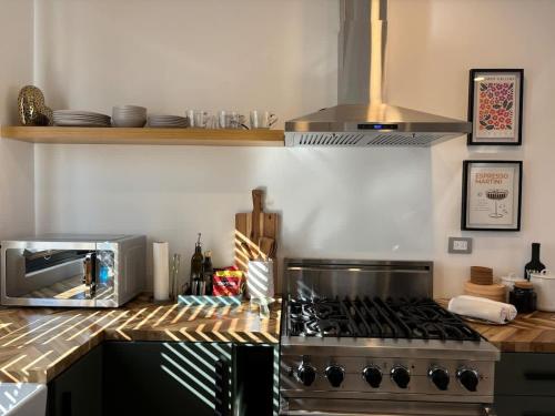 a kitchen with a stove and a microwave at Ensenada Valle PH in Ensenada