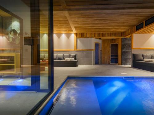 une piscine dans une maison avec un salon dans l'établissement Chalet Happysnow - OVO Network, au Grand-Bornand