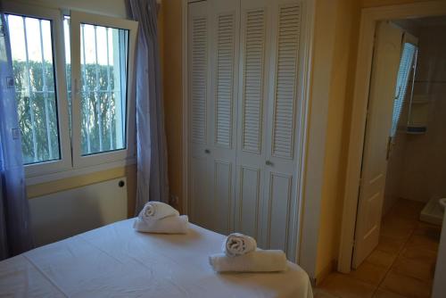 a bedroom with two towels on a bed with a window at Anacasa Picasso Oliva Nova CH1400 in Oliva