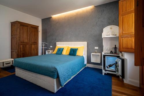 a bedroom with a bed with yellow and blue pillows at Marcus Suite in Cagliari