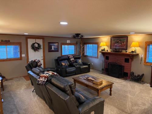 a living room with leather furniture and a fireplace at Gonzales Cozy Little Bear Cabin in Ruidoso