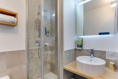 a bathroom with a sink and a shower at Sure Hotel by Best Western Sarlat-la-Canéda in Sarlat-la-Canéda