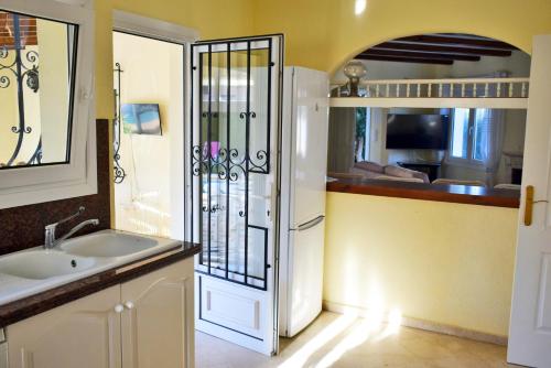 eine Küche mit Spüle und einem weißen Kühlschrank in der Unterkunft Anacasa Villa Renoir Oliva Nova CH1015 in Oliva