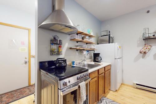 a kitchen with a stove and a sink and a refrigerator at SlopeSide Escape in Newry