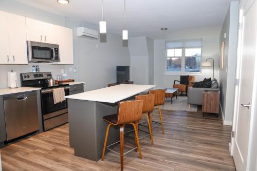 a kitchen and living room with a table and chairs at Luxury apartment with gym, steps from commuter rail #4011 in Reading