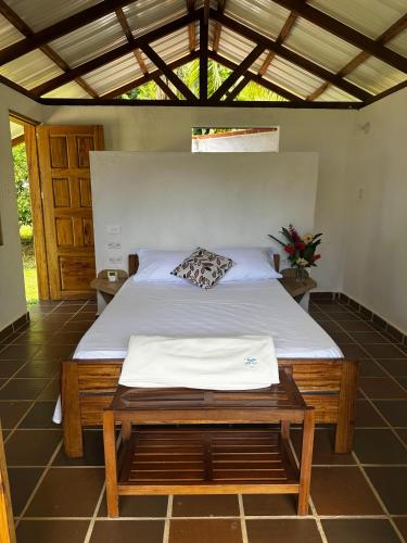 a bedroom with a bed with a wooden frame at Pacific Waves Hostel & Surf in El Valle