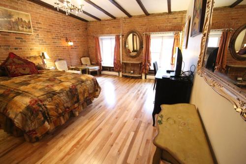 a bedroom with a bed and a brick wall at Castel d'Amérique Française in Quebec City