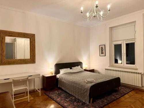Un dormitorio con una cama, un escritorio y un espejo. en Apartamenty Zasanie, en Przemyśl