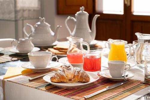 a table with cups and plates of pastries and drinks at Marcus Suite in Cagliari