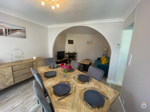 une salle à manger avec une table et des chaises en bois dans l'établissement Maison Deauvillaise, à Deauville