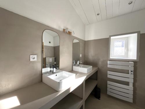 ein Badezimmer mit zwei Waschbecken und einem großen Spiegel in der Unterkunft Maison LA BEURELIÈRE proche Plage in Sainte-Marie-de-Ré