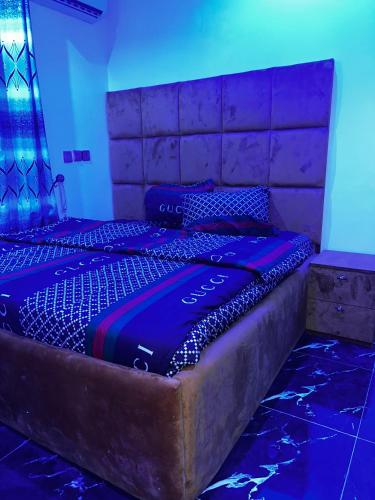 a large bed in a room with blue lights at Esthercy Hotels in Okunola