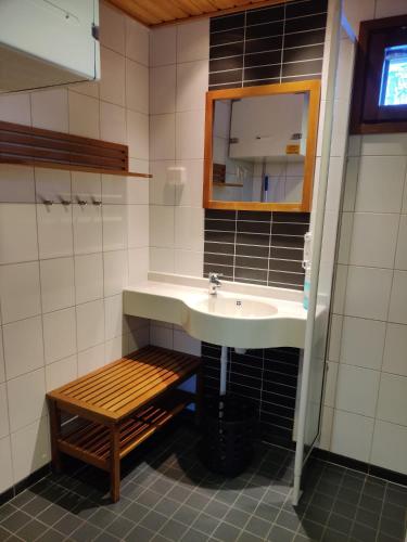 a bathroom with a sink and a wooden bench at Kylpyla SPA, Saimaa Villa B3 in Imatra
