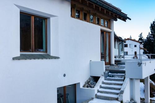 a white house with stairs and a window at Chalet a Saint Moritz with Sauna Privata in Pontresina