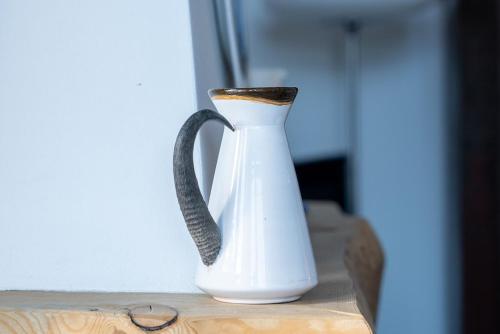 a white vase with a black handle on a table at Chalet a Saint Moritz with Sauna Privata in Pontresina