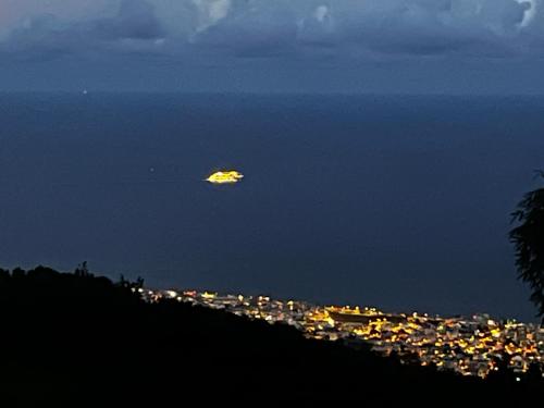 a kite flying over a city at night at Les Chalets de marie 2 - Vue mer, Jacuzzi SPA privatif dans le chalets Sans vis à vis in Saint-Denis