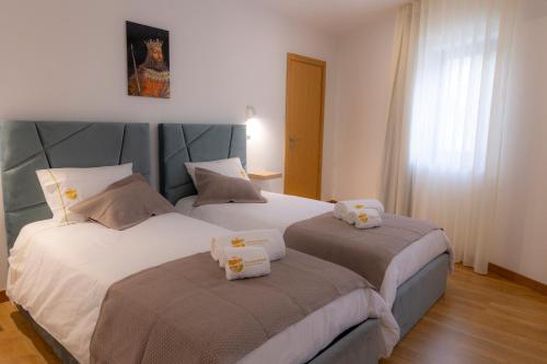 two beds sitting next to each other in a bedroom at Figuras Mágicas in Trancoso