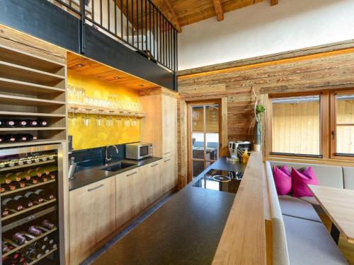 a kitchen with a long table and some wine bottles at Gamslodges in Goldegg