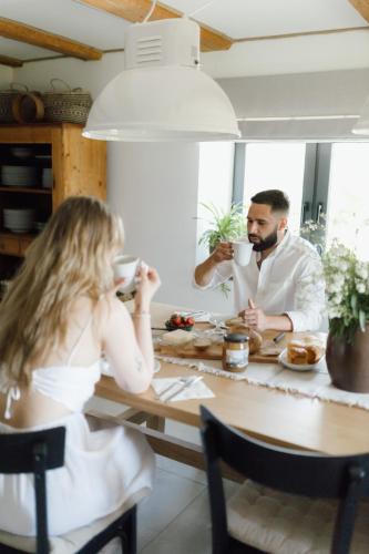 a man and a woman sitting at a table drinking coffee at Dobre Historie in Leśna