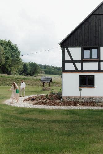 a couple of people walking towards a building at Dobre Historie in Leśna