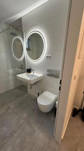 a bathroom with a toilet and a sink and mirror at Ruhige Wohnung mit Garten in Schönefeld