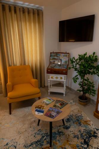 a living room with a chair and a table at Figuras Mágicas in Trancoso