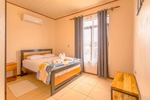 a bedroom with a bed with a teddy bear on it at Casa vacacional cerca de la Fortuna San Carlos in Tanque
