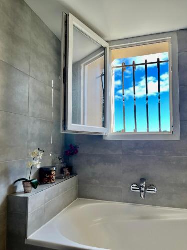 une baignoire dans une salle de bain avec une fenêtre dans l'établissement Villa JELOD, piscine jardin sans vis à vis, à Saint-Rémy-de-Provence