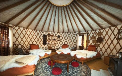 a room with three beds and a table in a yurt at Le Salon des Inconnus in Namur
