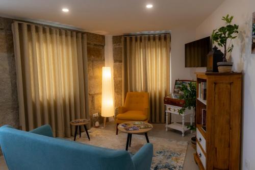a living room with a blue couch and a chair at Figuras Mágicas in Trancoso