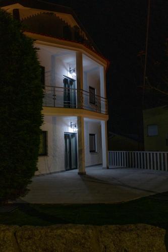 a large white building with a balcony at night at Figuras Mágicas in Trancoso