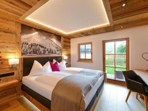 a bedroom with a large bed in a room with wooden walls at Gamslodges in Goldegg